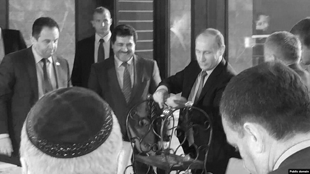 Putin accepts the gift of a golden cradle